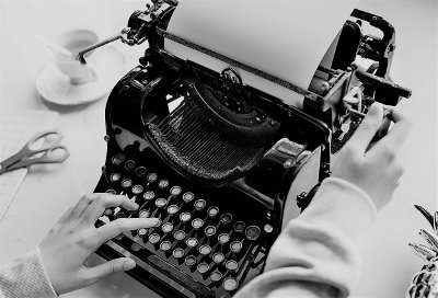 Woman typing on old typewriter