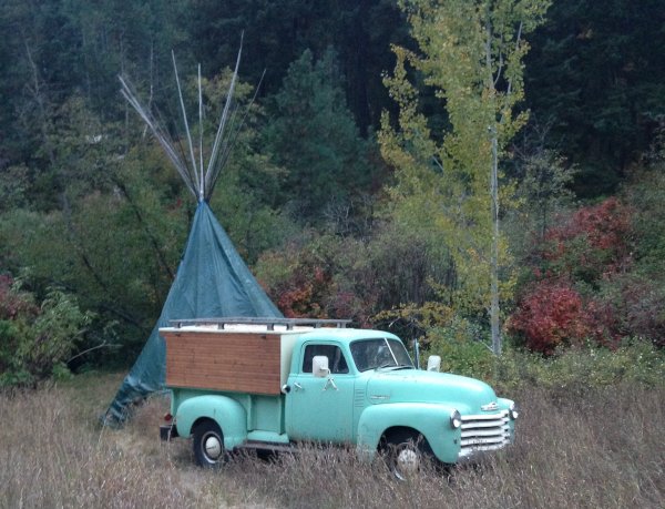 1951 Chevy pickup truck named Irene, with canopy next to a teepee.